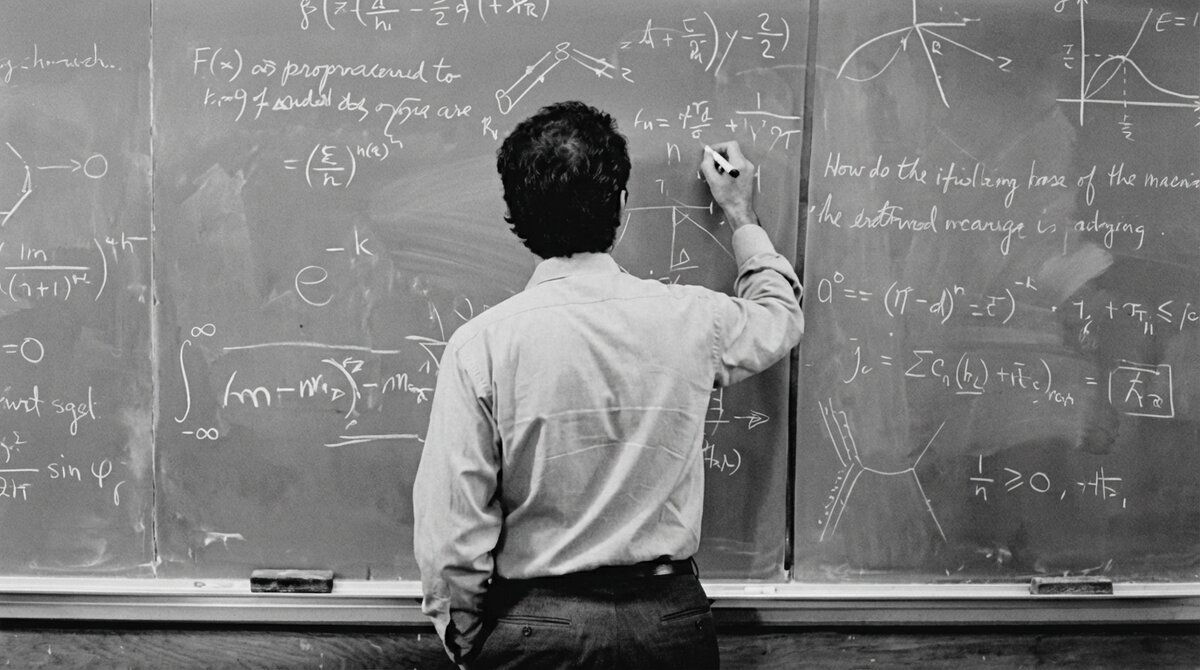 The Physics Way — a teacher writing physics equations on a chalkboard
